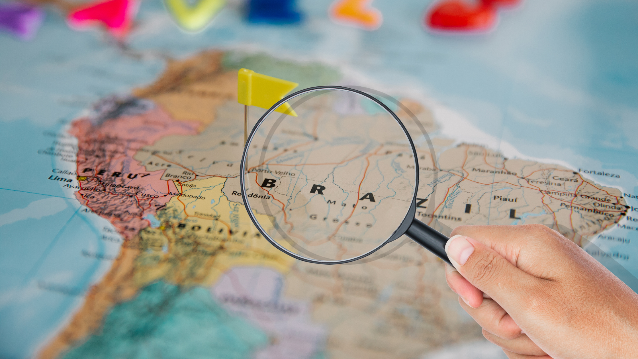 A map of Latin America with a magnifying glass, representing popular nearshore staff augmentation destinations for hiring software engineers