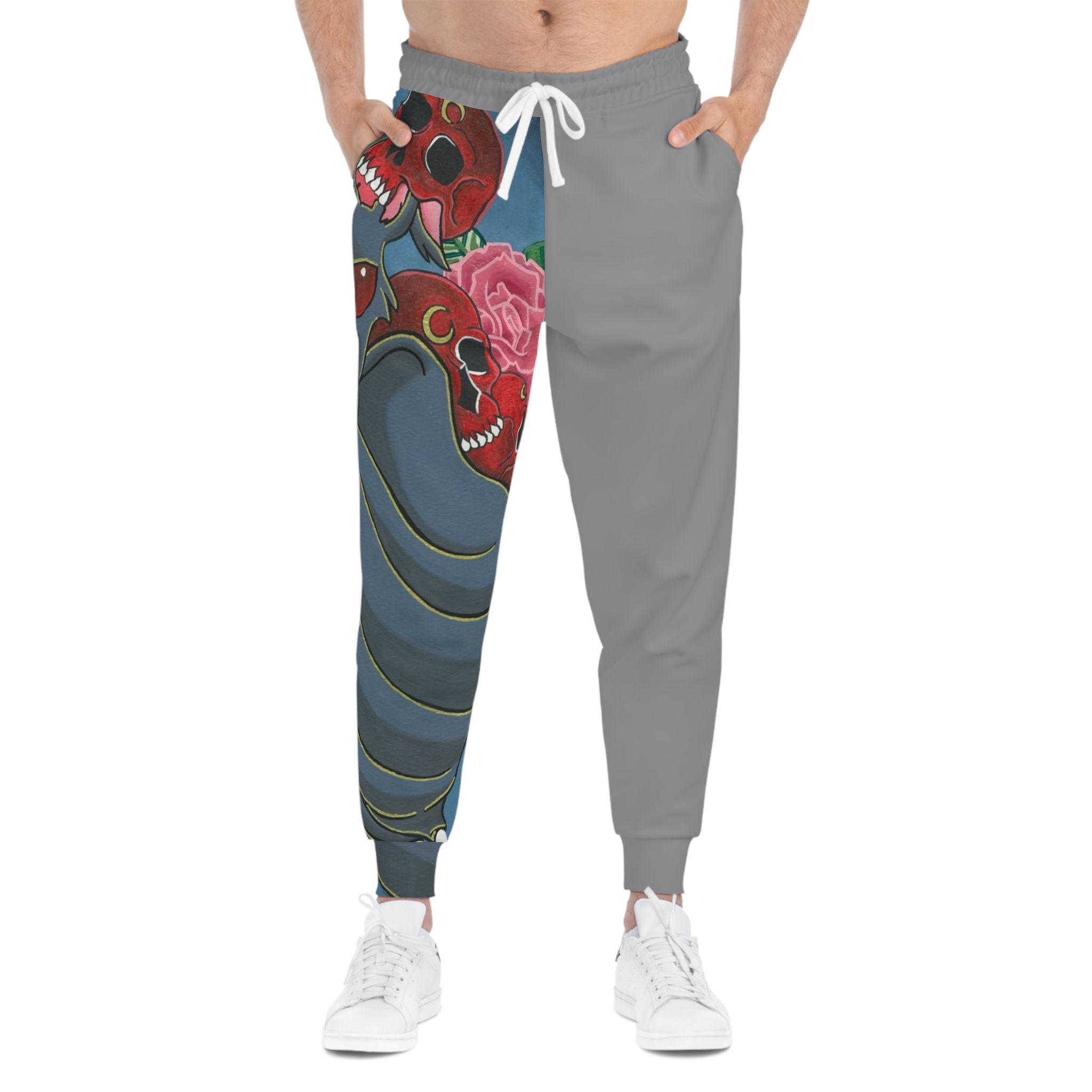 Graphic joggers with red skulls, roses, and blue waves on left leg, gray right leg