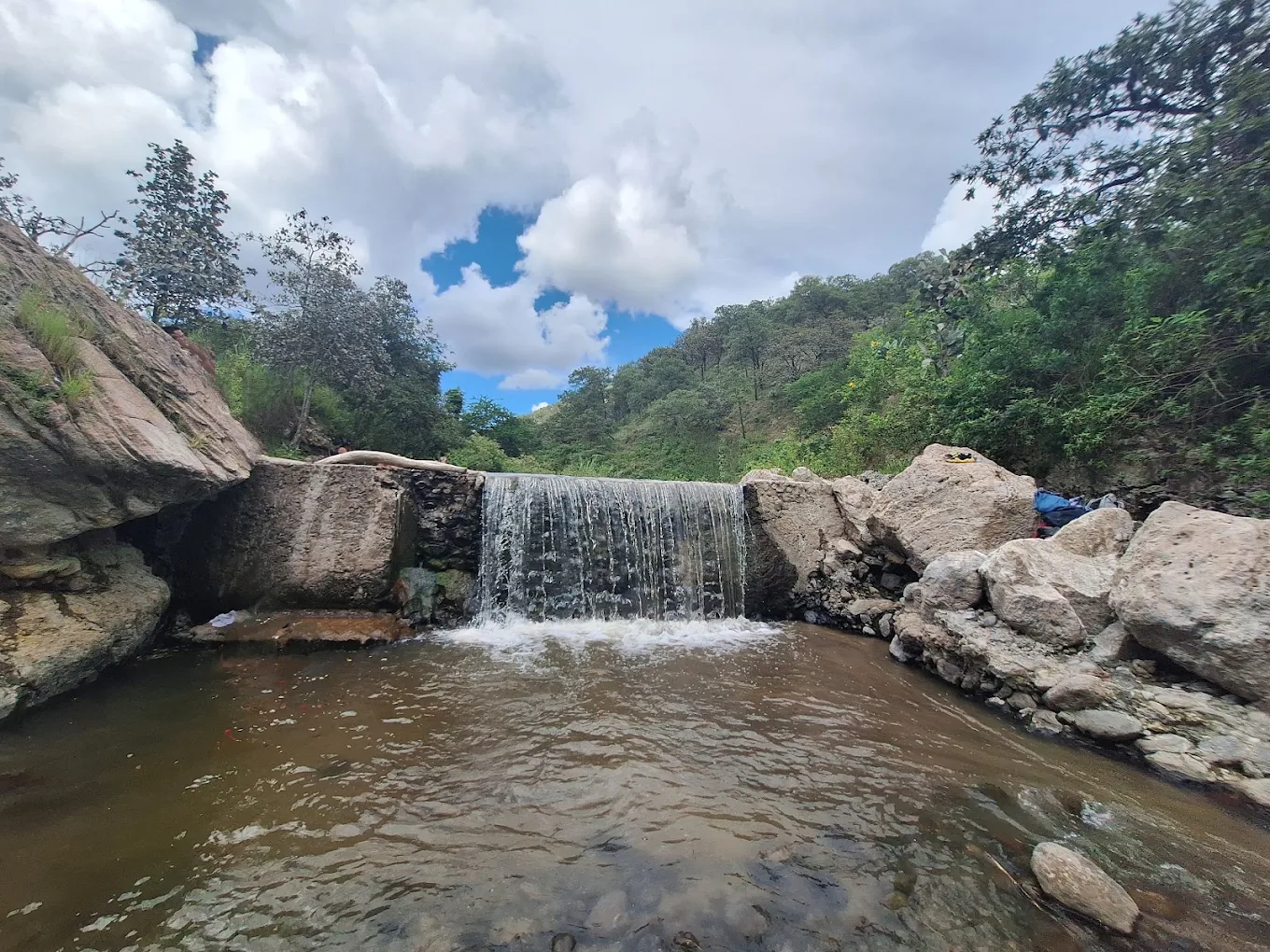 Cascada de agua clara cayendo en una poza del Río Caliente.