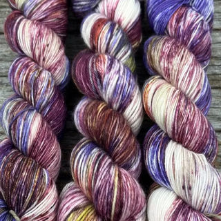 3 skeins of white, maroon, and purple yarn