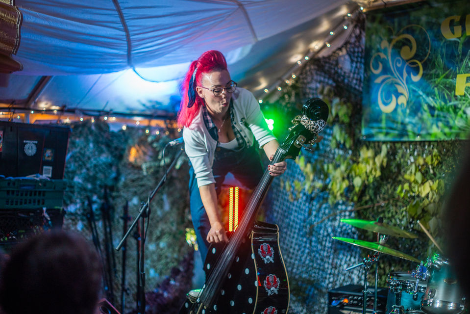 Woman standing on her double bass while performing