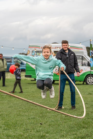 A child jumps over a giant skipping rope