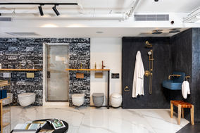 עיצוב אולם תצוגה בסגנון תעשייתי מגניב ובועט, חיפוי קיר בדוגמת בריקים בגוונים שחור לבן, סטנד מעץ וברזל לתצוגת מוצרים