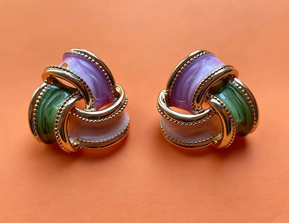 The Amara sculptural knot earrings with lilac, sage green and blush pink enamel woven through gold-plated bands.