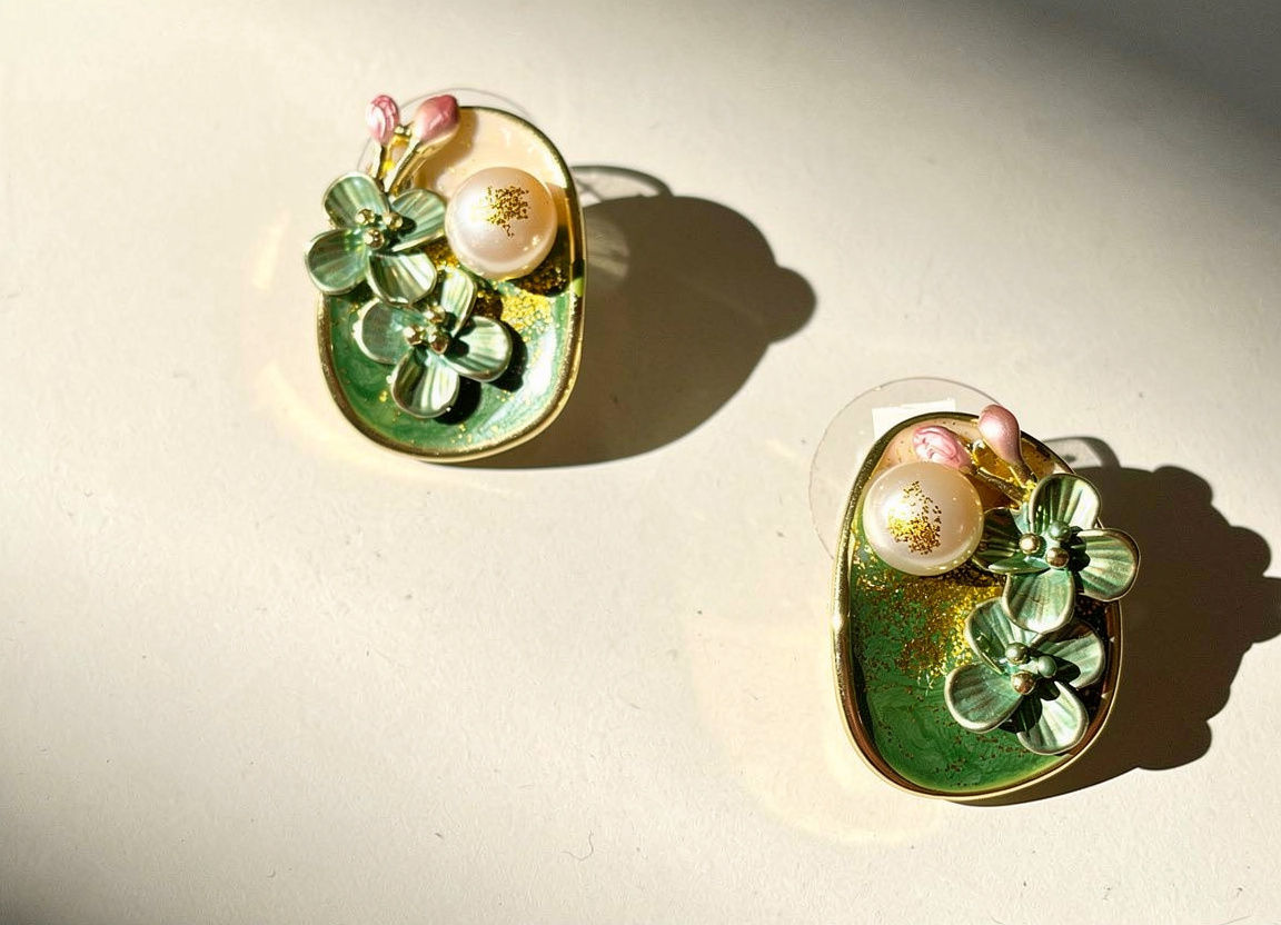 The Serene Green Garden Pearl Earrings with sculptural sage flowers, faux pearl and green resin with gold leaf.
