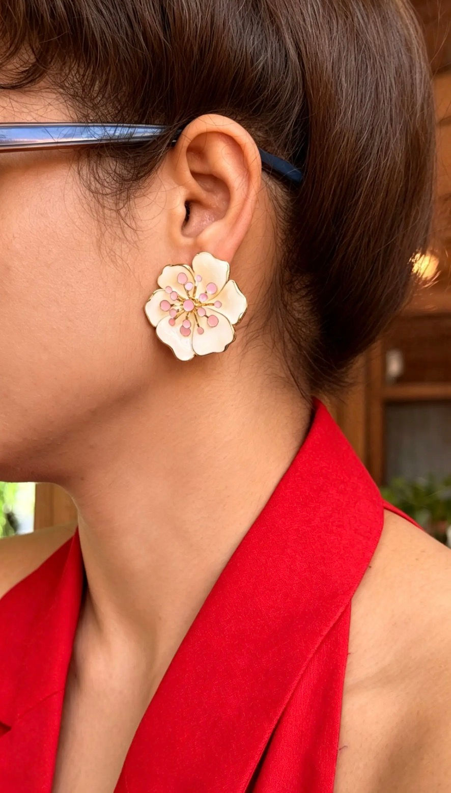 Model wearing The Clara ivory white floral statement earrings with gold-plated brass, ivory enamel petals and soft pink bead