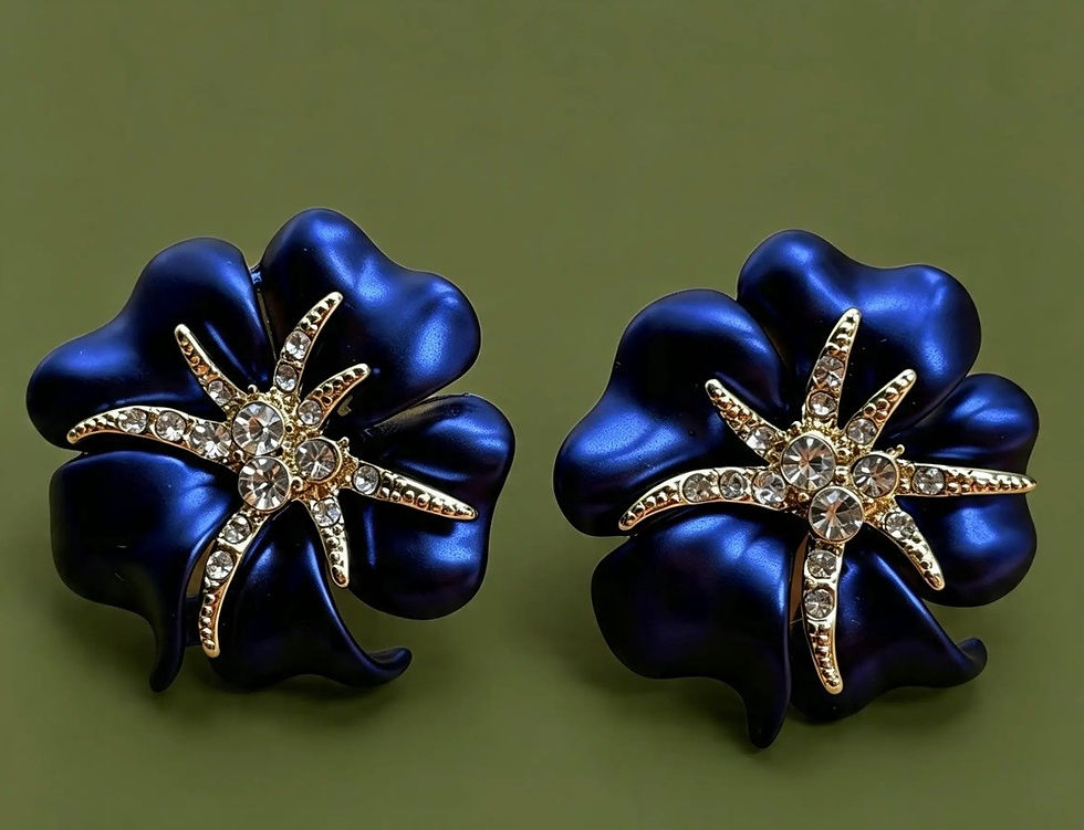 Close-up of The Serene navy blue flower earrings featuring a pavé crystal starburst and sc