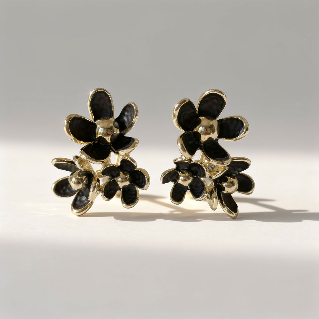 The Serene Black Double Floral Earrings featuring layered black textured enamel flowers with gold-plated detailing.