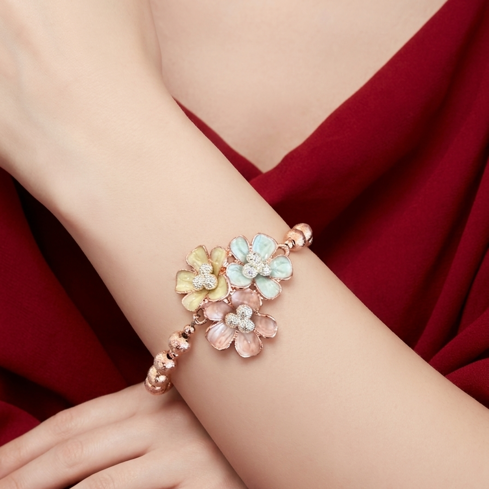Model wearing Rose gold-plated brass bracelet with enamel flower cluster and cubic zirconia centres, lobster clasp.