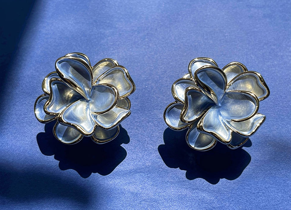 The Arwen periwinkle blue floral statement earrings in gold-plated brass with pearlescent enamel finish.