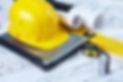 Image of yellow helmet over laptop with ruler placed on blueprint of house.jpg