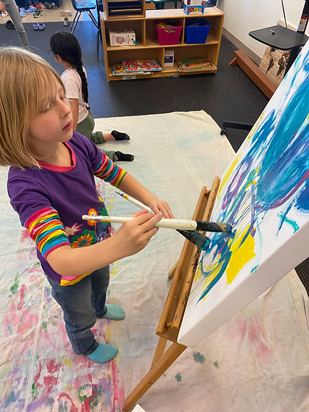 Young girl painting on easel, colorful artwork, Preschool & VPK, creative learning environment