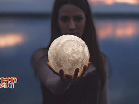 Mystical woman holding the full moon in her hand