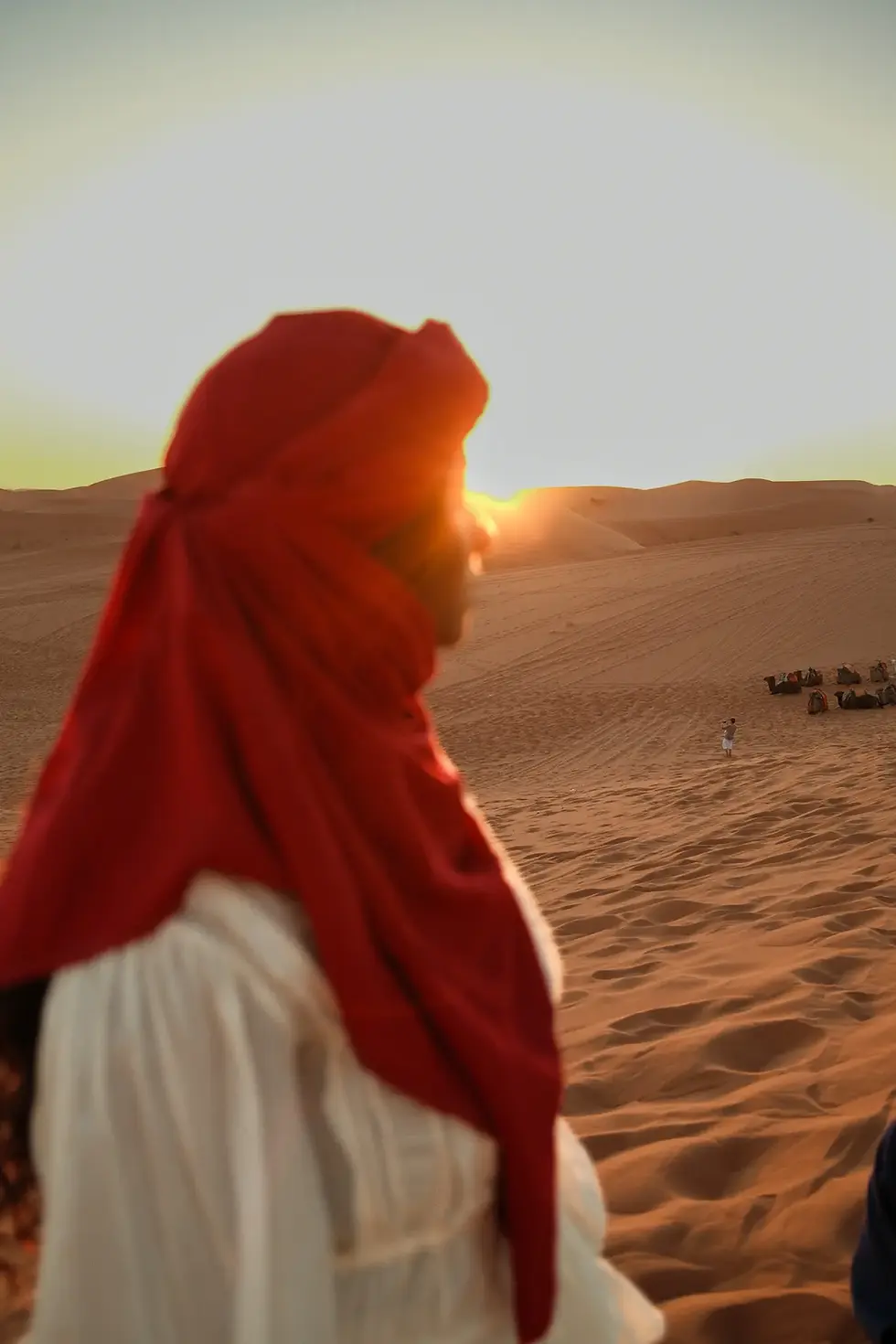 Female solo traveler taking in sunset over the Sahara in Morocco on a group trip with FTLO Travel