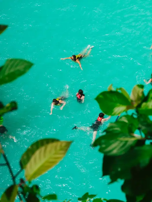 aerial view of swimmers in turquoise waters in the Philippines