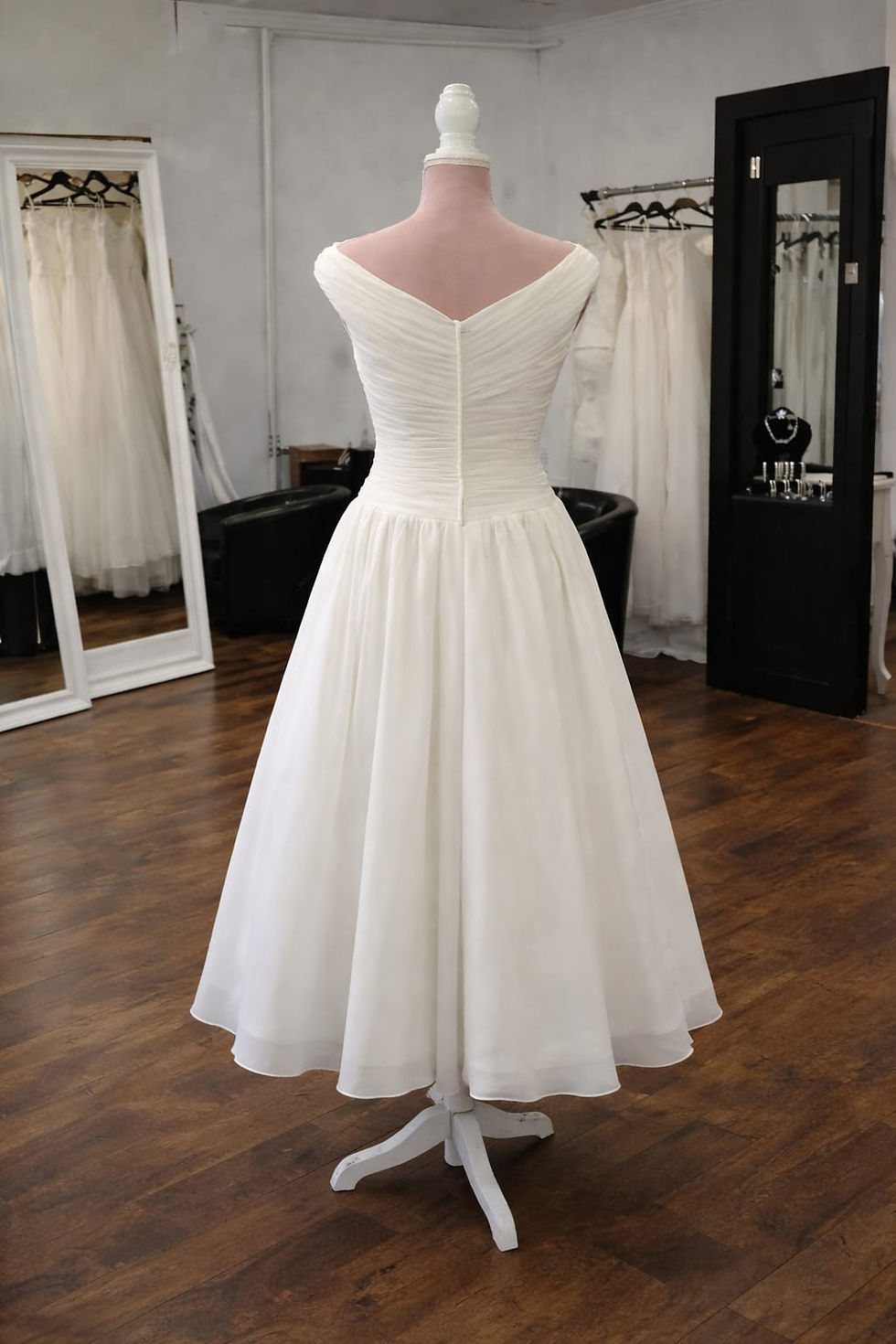Elegant ivory tea length wedding dress with off the shoulder neckline and ruched bodice