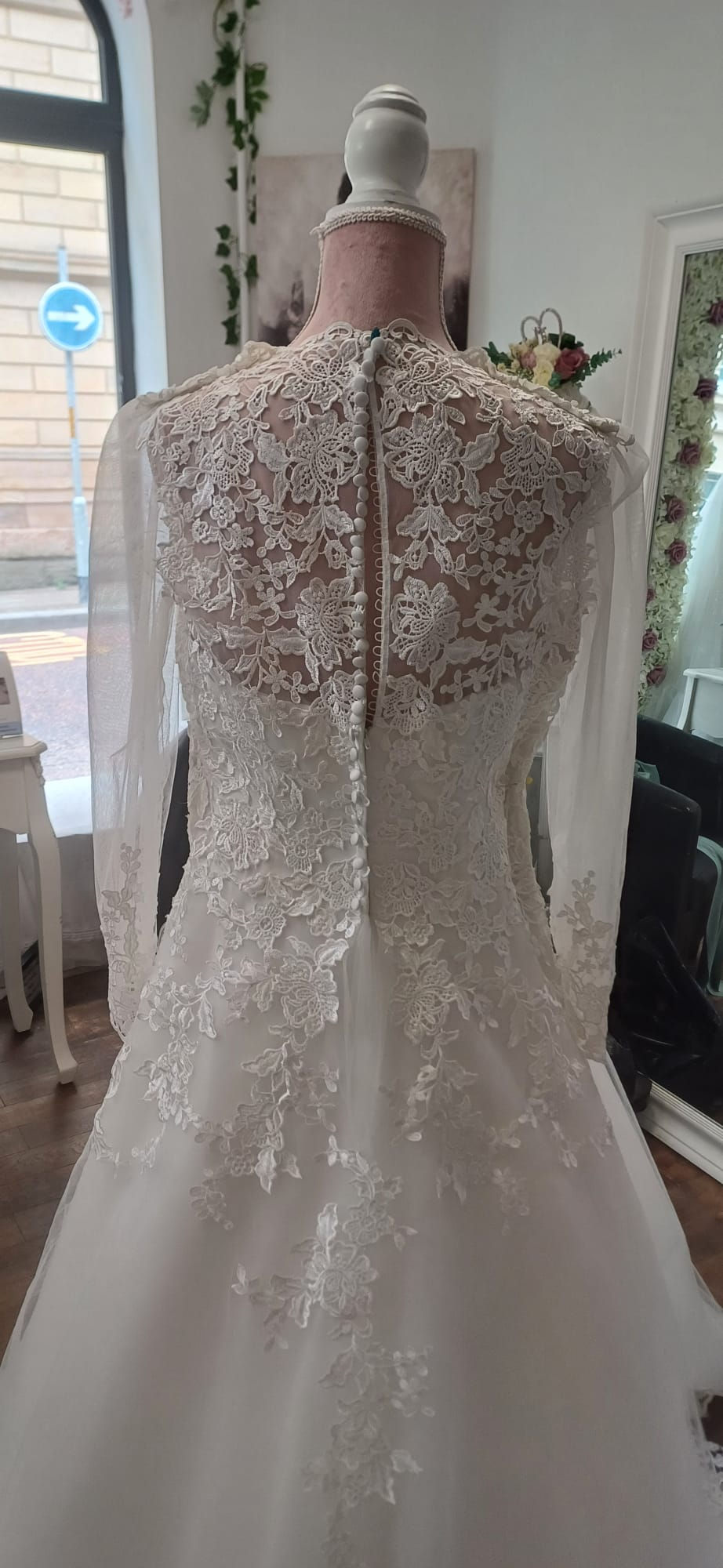 Back view of ivory lace wedding dress with sheer lace panel and button detailing