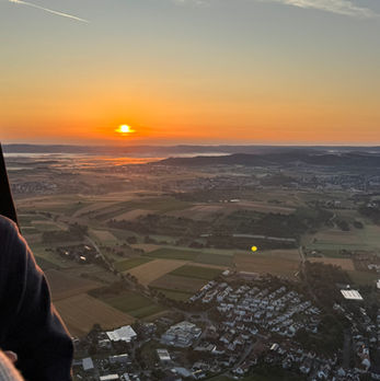 Ein Heißluftballon von Ballonfahrten Pfau schwebt über das malerische Remstal im Rems-Murr-Kreis, das idyllische Wieslauftal, den Ostalbkreis und die sanften Höhenzüge der Schwäbischen Alb – mit freiem Blick auf die Drei Kaiserberge Hohenstaufen, Rechberg und Stuifen in Baden-Württemberg