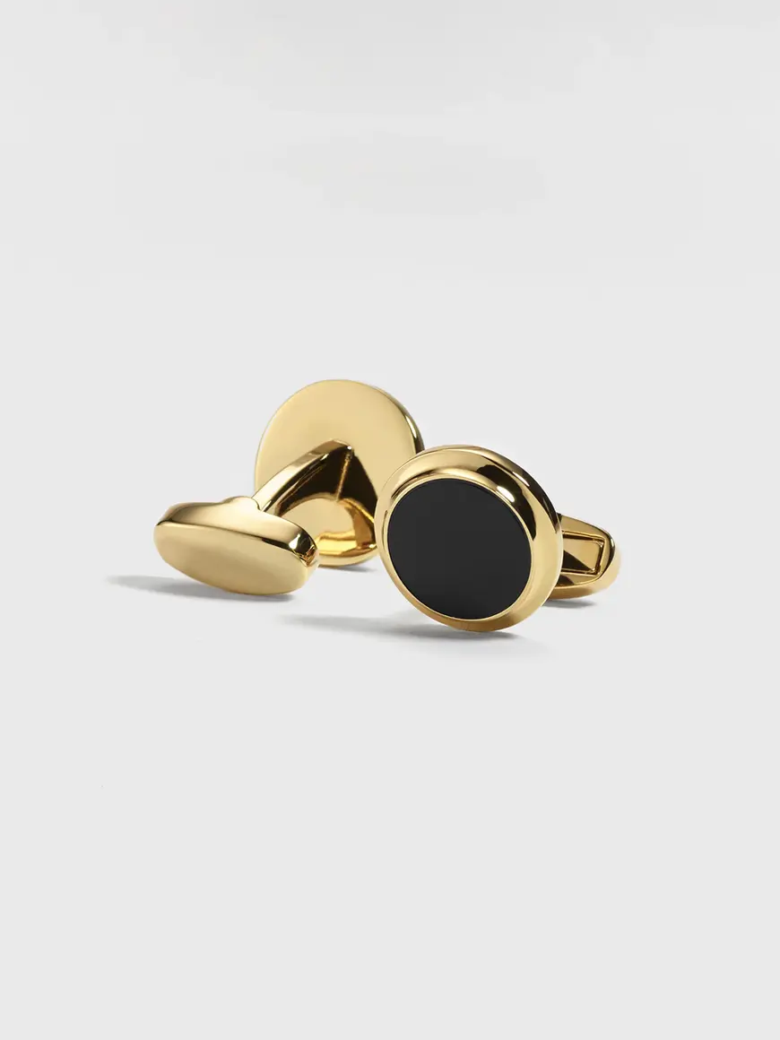 Black onyx and gold cufflinks with a round design and polished finish