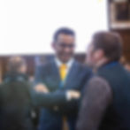 Jimmy at an event standing smiling in conversation with someone