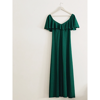 A beautiful long green dress on a hanger on a white wall _edited.png