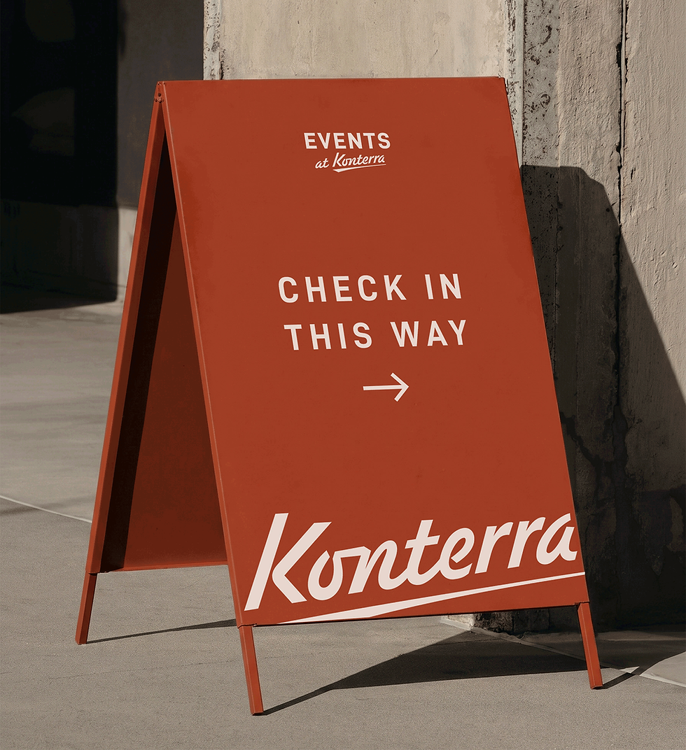 A branded A-frame poster directing event guests towards check-in