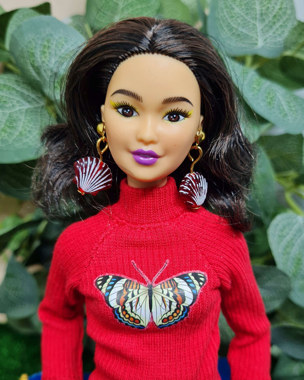 Thumbnail: Barbie is modelling a range of our Oceanic earrings in Scallop style