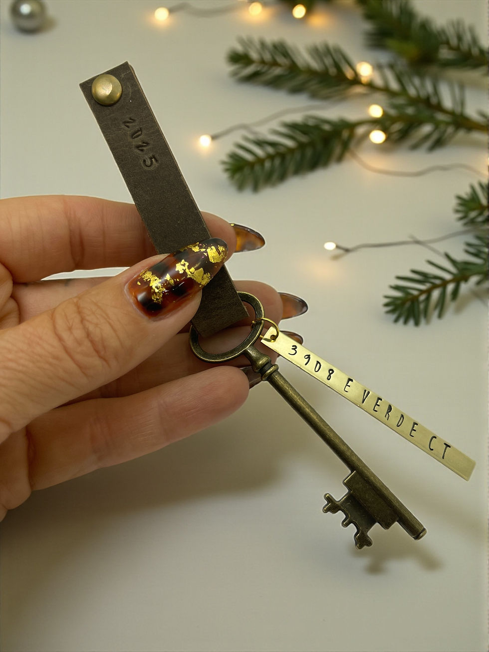 Thumbnail: hand holding leather and brass address tag with vintage brass skeleton key