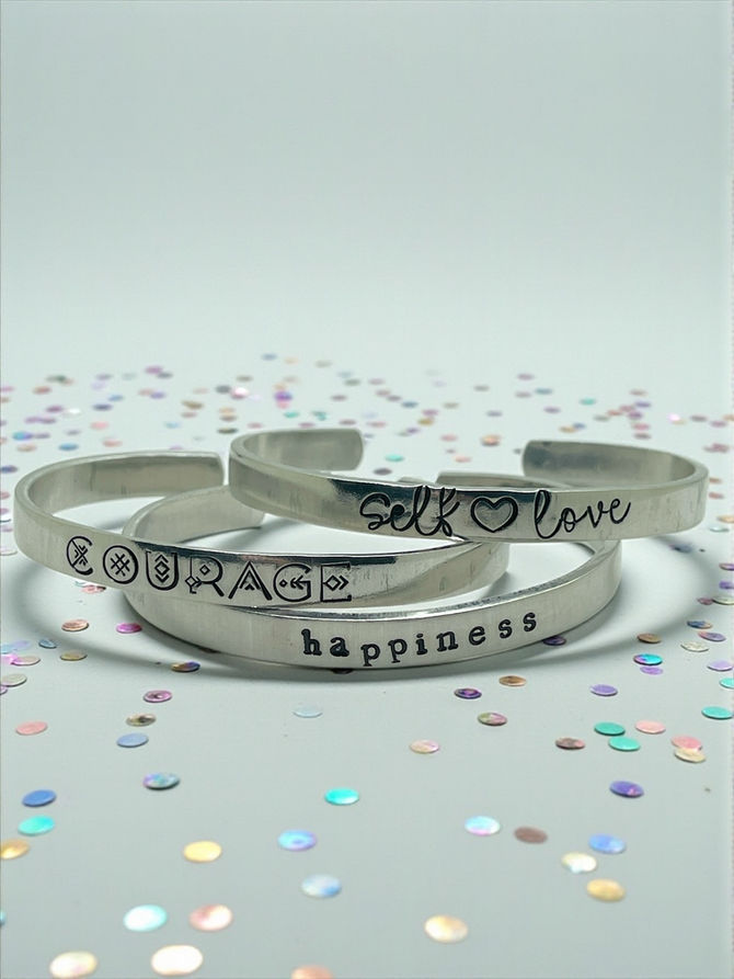 an image showing 3 silver cuff bracelets each hand stamped with a one word motivation mantra for the new year resolutions 2026