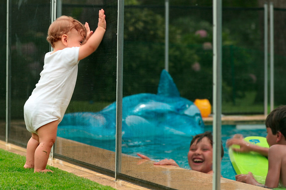 A cheerful baby plays in a pool, emphasizing the need for safety measures around water areas for toddlers.