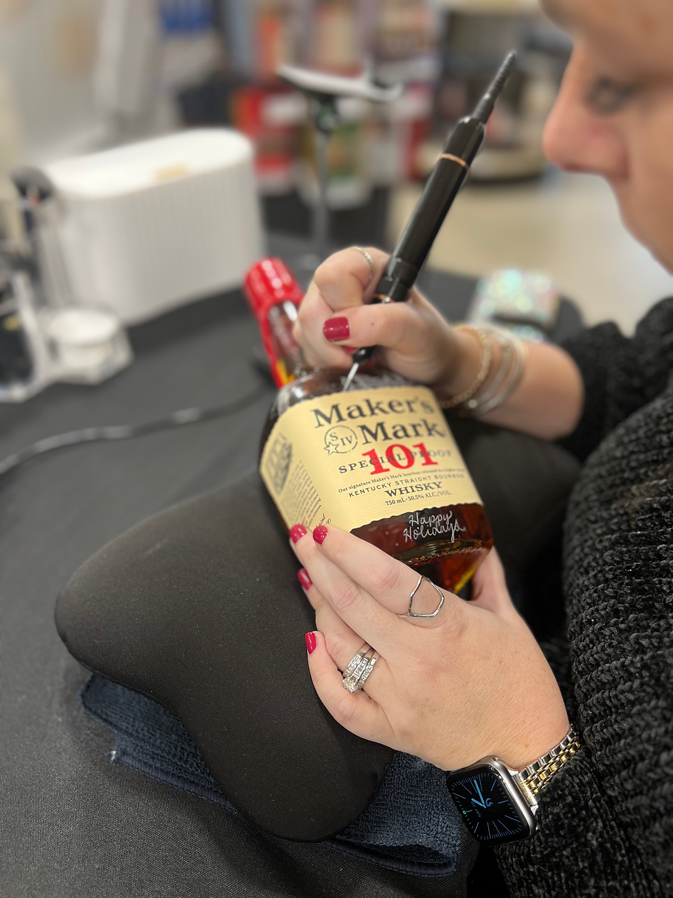 Amanda Elliott, a professional live event calligrapher, performing elegant hand engraving on Maker's Mark
at a luxury brand activation in downtown Chicago. She is creating custom calligraphy in real-time, adding a personalized and artistic touch to the event experience.