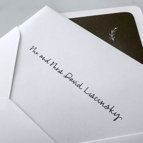A close-up of a white wedding envelope featuring elegant black calligraphy, showcasing the guest's name in a refined script. Created by Amanda Elliott of Letters from Elliott, Iowa & Chicago.
