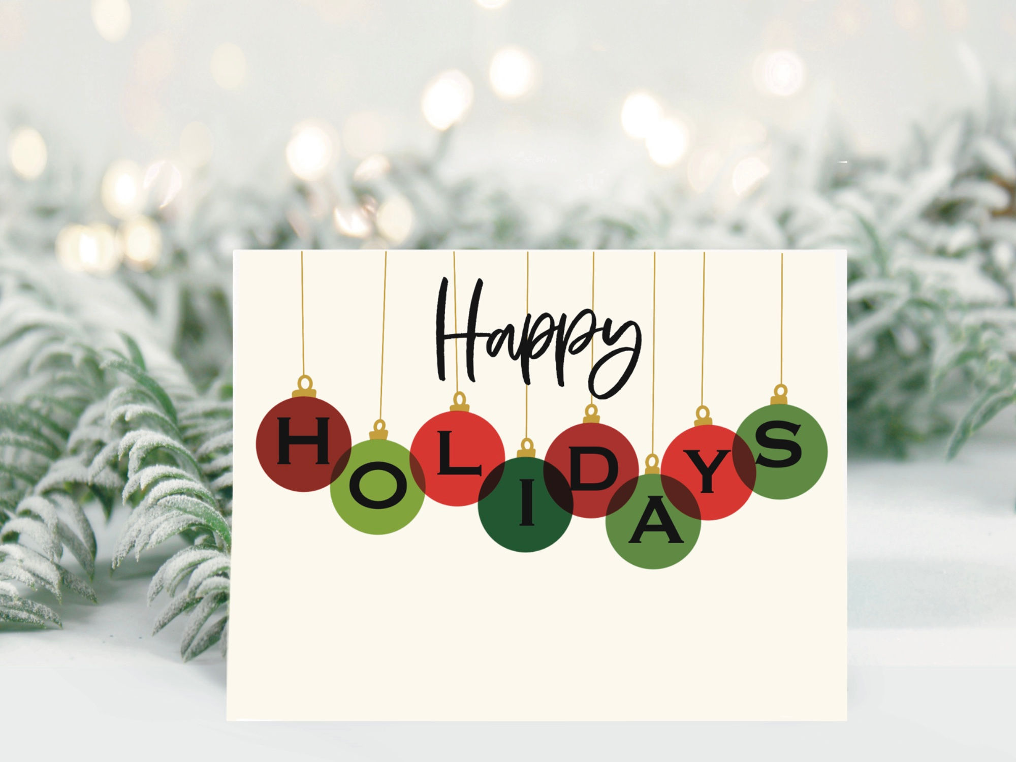 Hand-lettered holiday greeting card with “Happy Holidays” in script and ornaments in red and green by Letters from Elliott