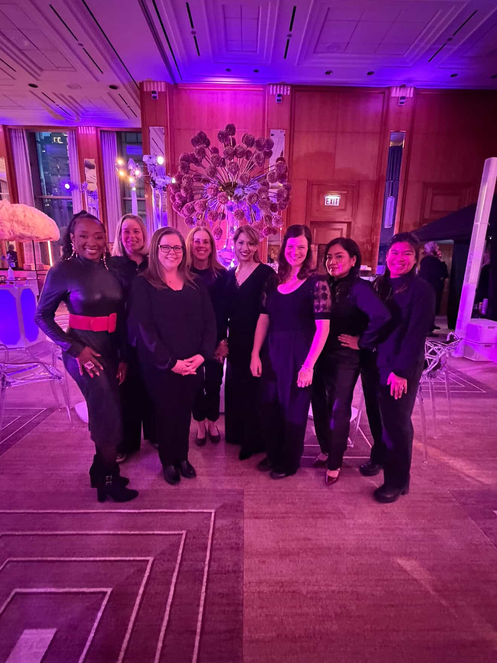 Team of professional live event calligraphers and engravers collaborating at a luxury indoor brand activation, providing multi-artist personalization services for a high-volume event.