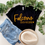 Thumbnail: Louisa-Muscatine Falcons black t-shirt styled with jeans and a hat, featuring a hand-lettered design by Letters from Elliott