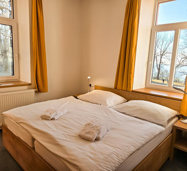 Čtyřlůžkový pokoj s výhledem do přírody a na klášter.