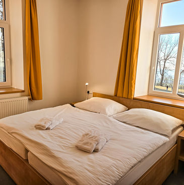 Čtyřlůžkový pokoj s výhledem do přírody a na klášter.