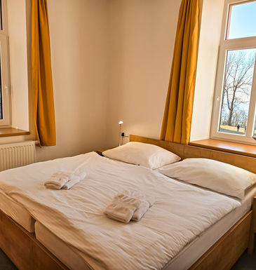 Čtyřlůžkový pokoj s výhledem do přírody a na klášter.