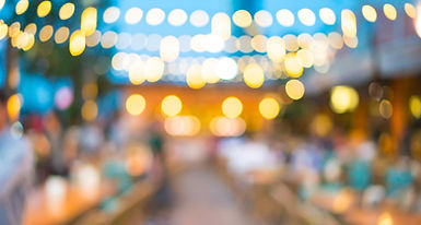 Image of wooden table in front of abstract blurred restaurant lights background