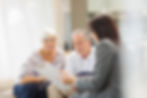 Financial advisor with older couple discussing documents