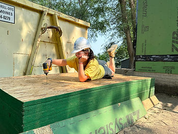 Construction worker lying on flat of plywood