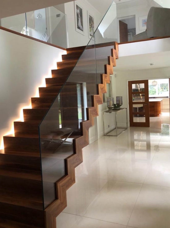 Custom made steel-framed and solid oak clad staircase with bespoke glass balustrade.