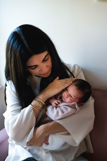 mom touching newborn baby
