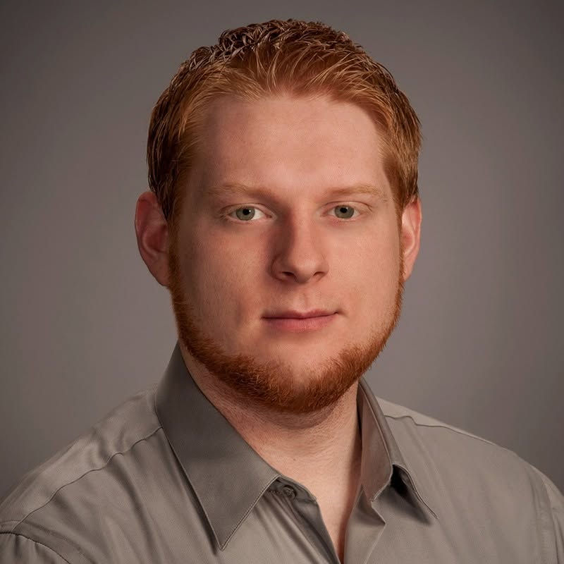 Portrait of a man with red hair and a beard.