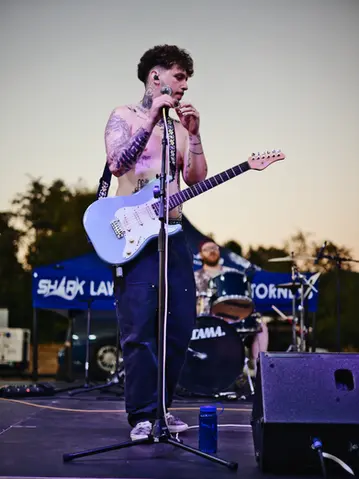 Musician performing live on stage with an electric guitar