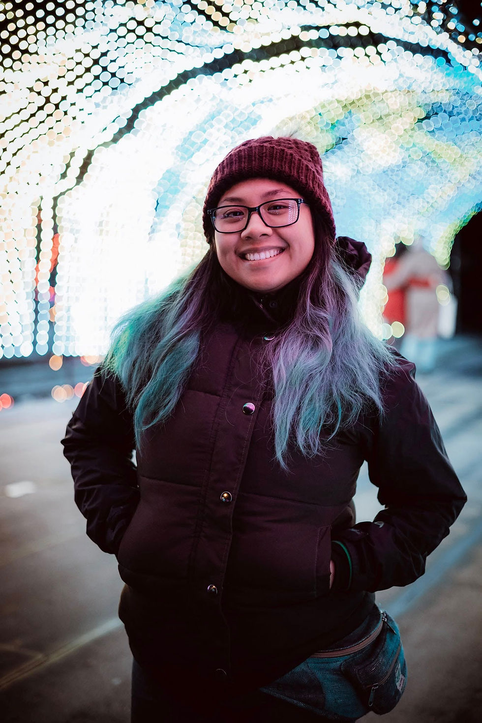 Team member with blue hair and beanie in a light tunnel