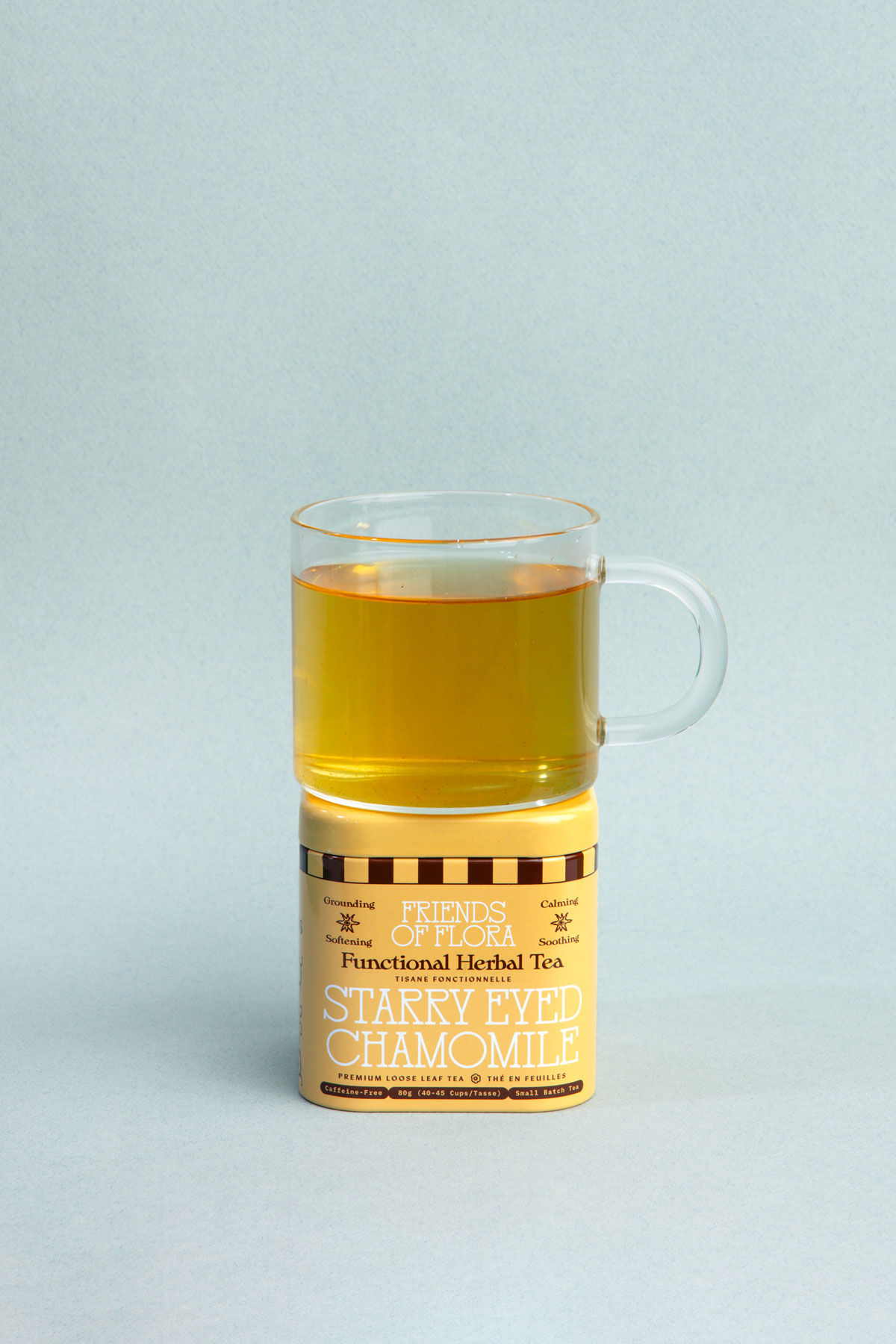 Closed aluminum tin of Starry Eyed Chamomile chamomile sleep tea with a brewed cup on top