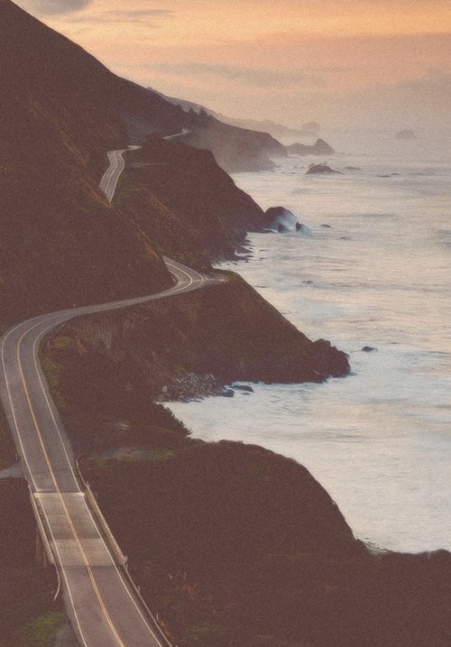 Highway 1 winding along the Big Sur coast at dusk
