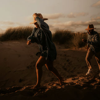 Playful couple running on the beach the day before their wedding in Barcelona
