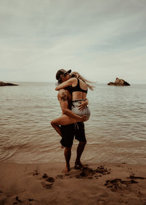 Playful couple kissing on the beach in Barcelona